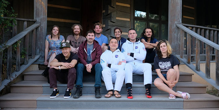 Photo of two astronauts and students sitting on steps
