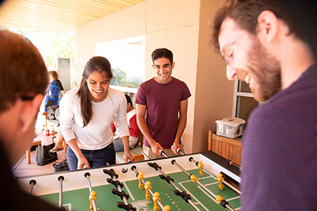 Young people playing table football. Link to Gifts by Estate Note